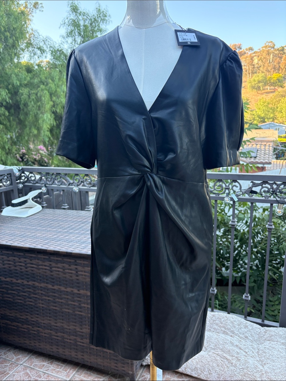 Black Faux Leather Twist-Front Mini Dress with pleated short sleeves and zipper.